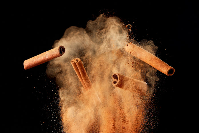 Food,Explosion,With,Cinnamon,Sticks,And,Powder,,On,Black,Background.